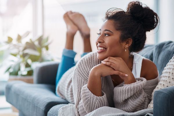A young woman on a sofa wearing a woolly jumper