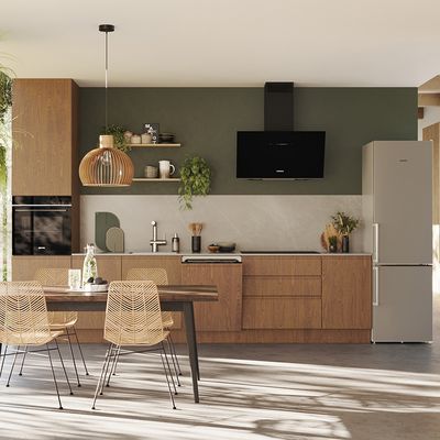 Moderne Küche mit Holzschränken, Geräten, Esstisch und Pendelbeleuchtung.