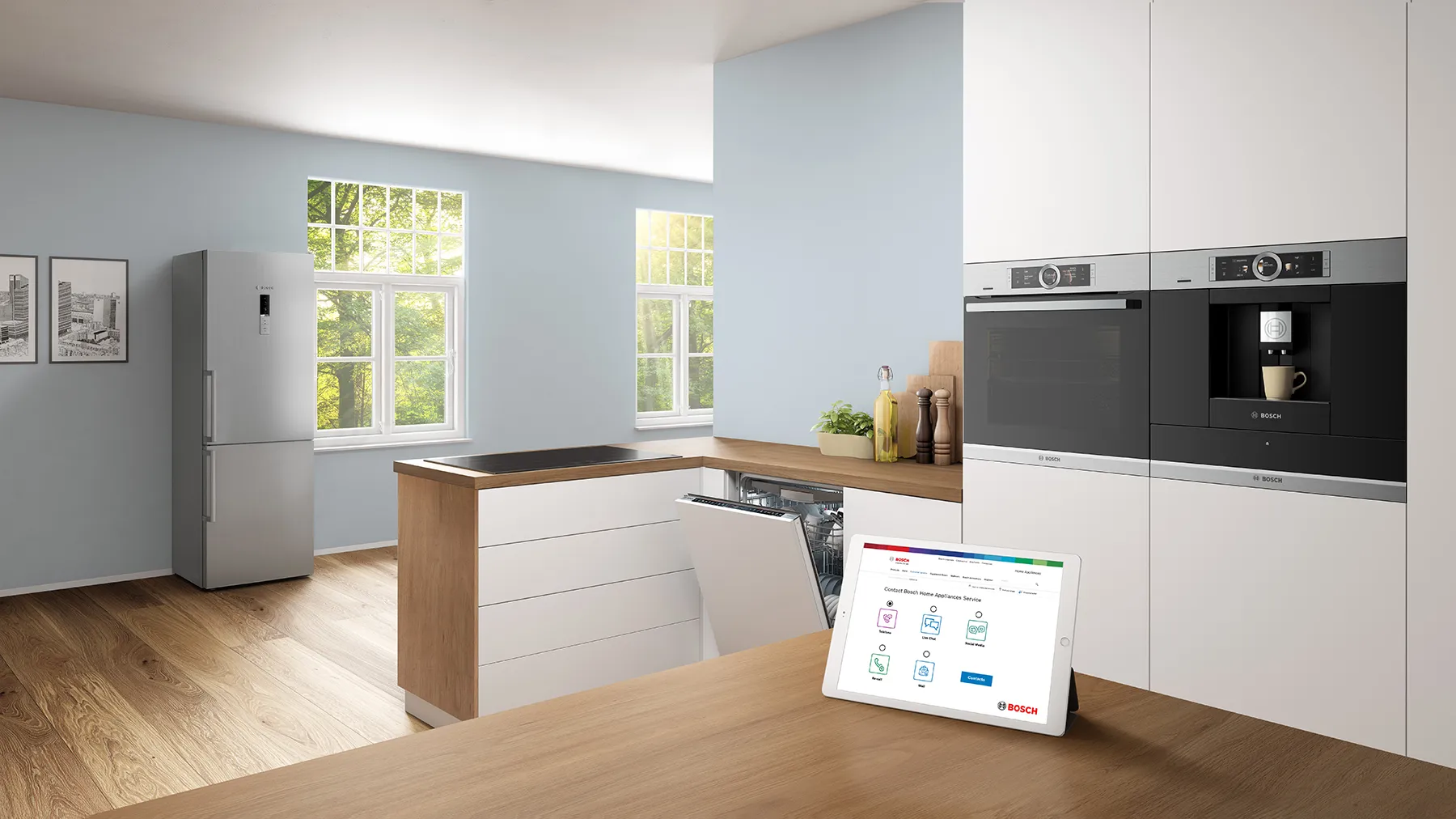 Une tablette affichant la page de contact Bosch sur un comptoir en bois dans une cuisine blanche.