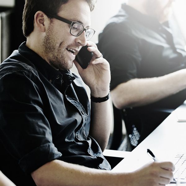 A man making a phone call and noting down information