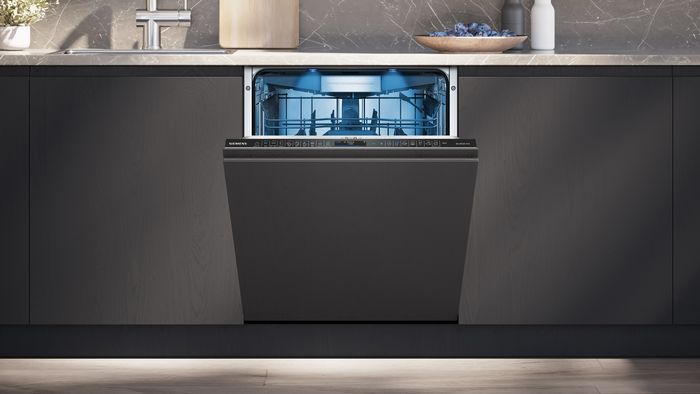 Lavavajillas totalmente integrable con la puerta semi-abierta en una cocina de diseño